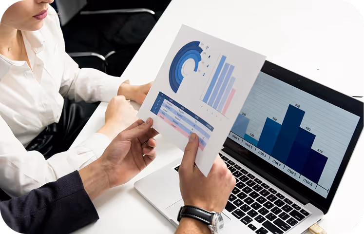 People checking charts at a desk with a laptop.