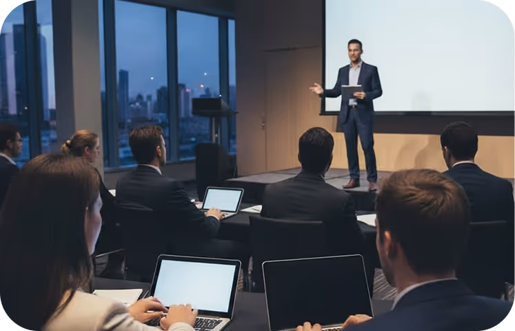 People in a conference room, listening to a presentation.