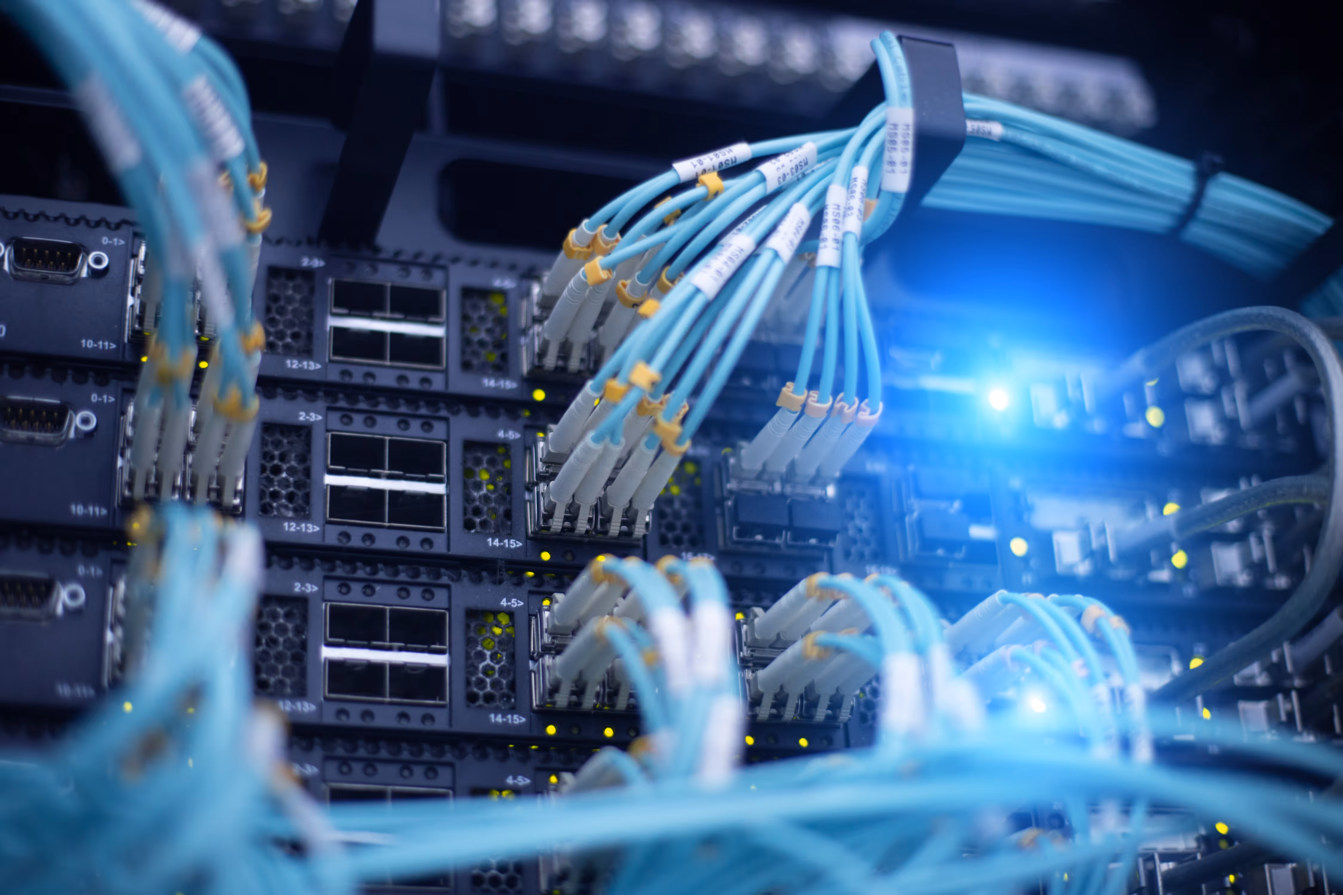 Server room with rows of black server racks and glowing abstract light trails indicating data flow.