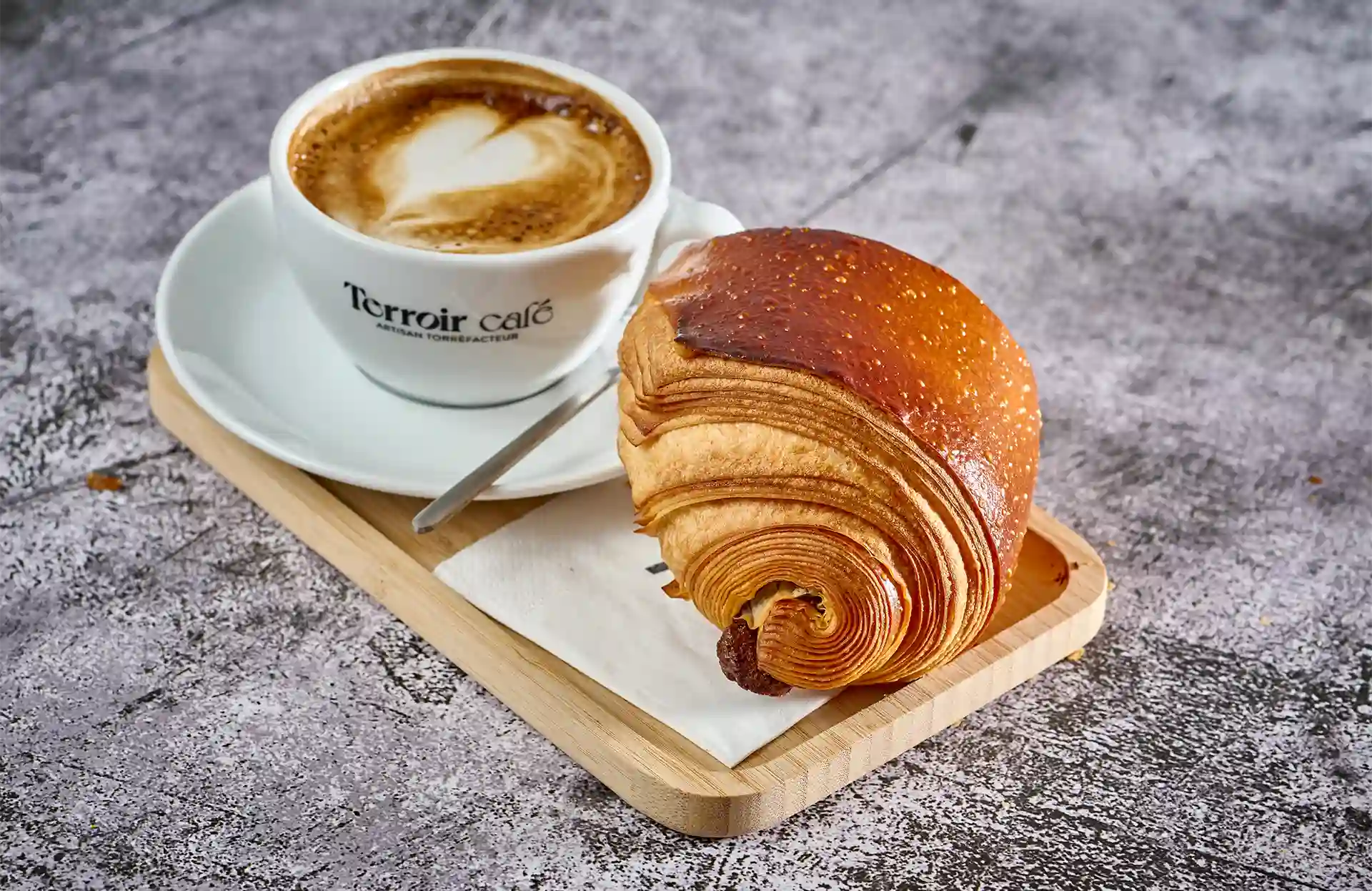 Expresso servi avec un pain au chocolat au salon de thé Alvéole à Annecy