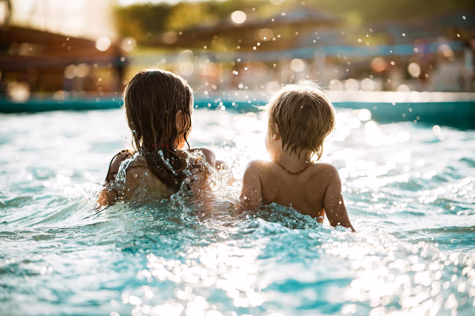 Two kids talking inside a swimming pool 