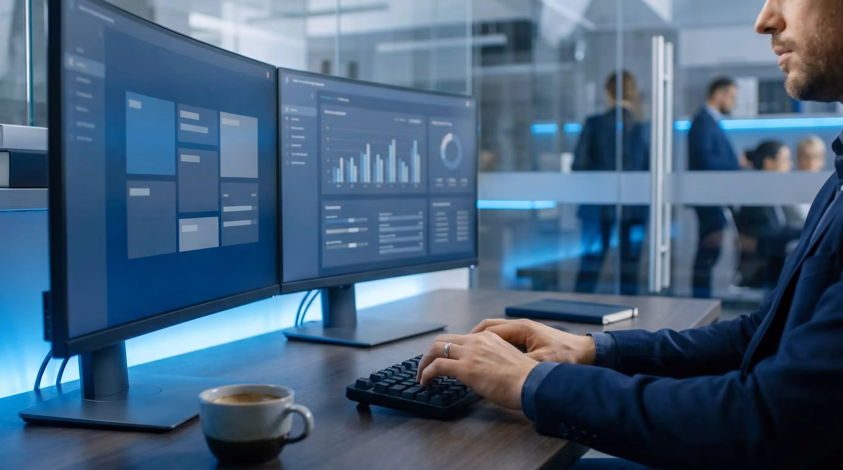 Mains tapant une newsletter SEO sur un clavier noir avec double ecran dans un bureau marine sombre