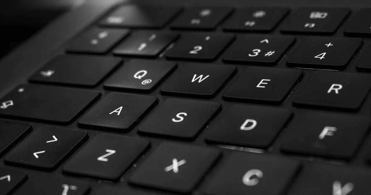 Close-up of hands typing a query into a laptop keyboard with the browser address bar visible