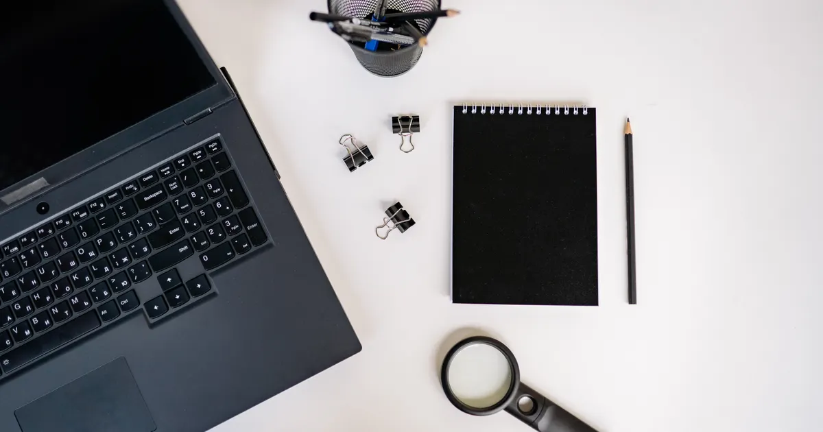 A magnifying glass resting on a laptop keyboard, representing alternative web search engines