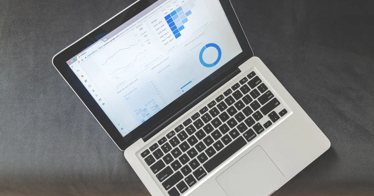 An SEO analytics dashboard with keyword ranking data open on a laptop