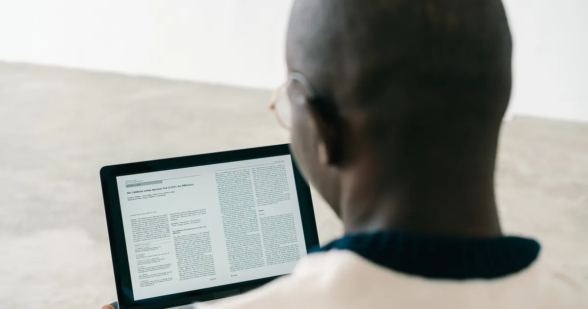 A person reading an article attentively on a screen