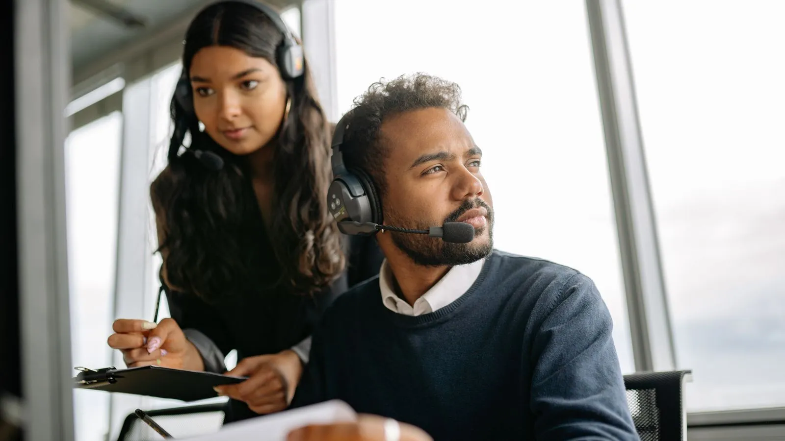 Dos comerciales B2B haciendo prospección telefónica con auriculares en una oficina