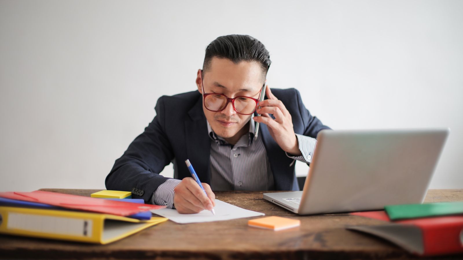 Sales representative on a B2B prospecting call at his desk with a laptop and notes