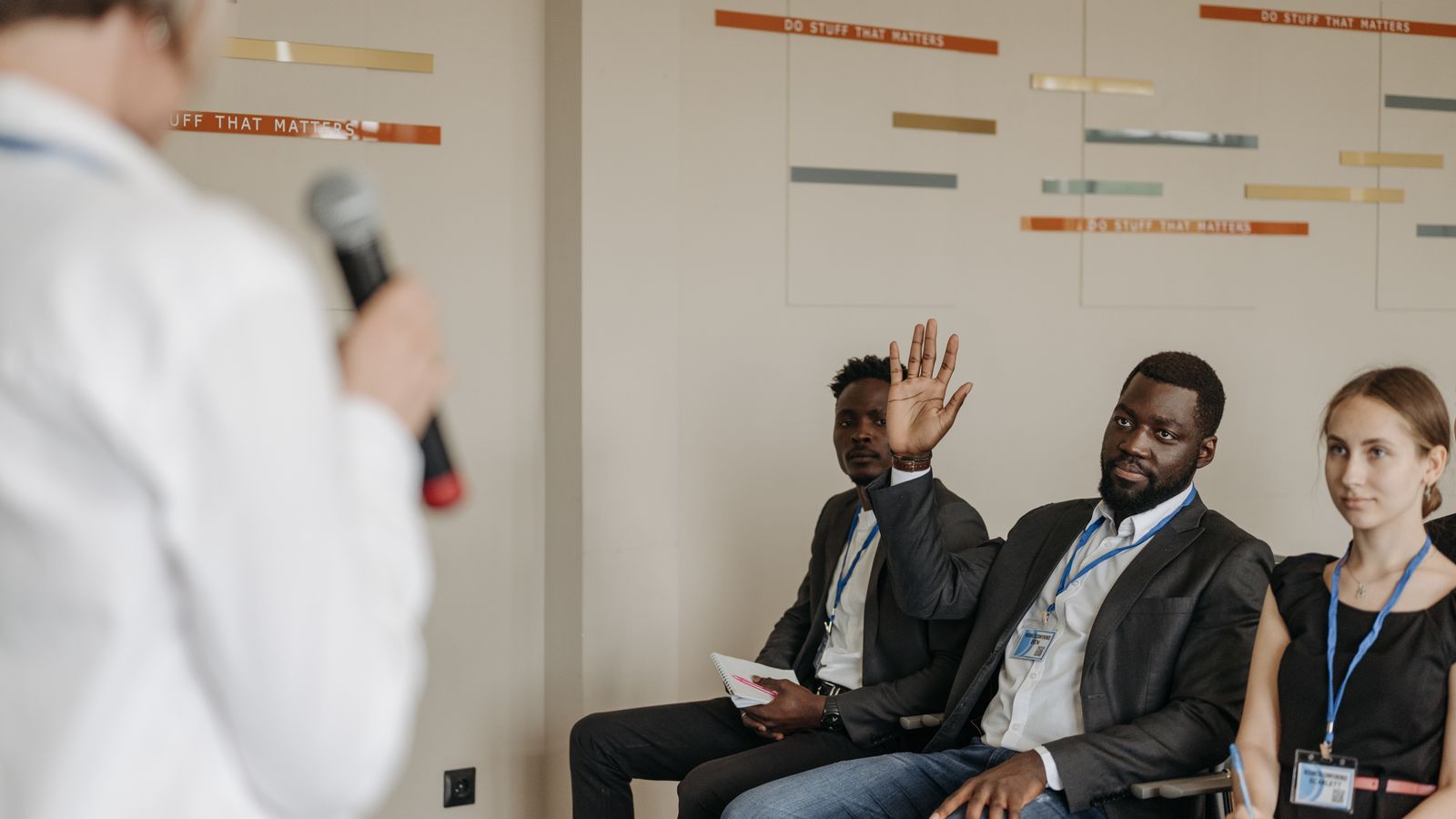 Participants asking questions to a speaker at a business conference