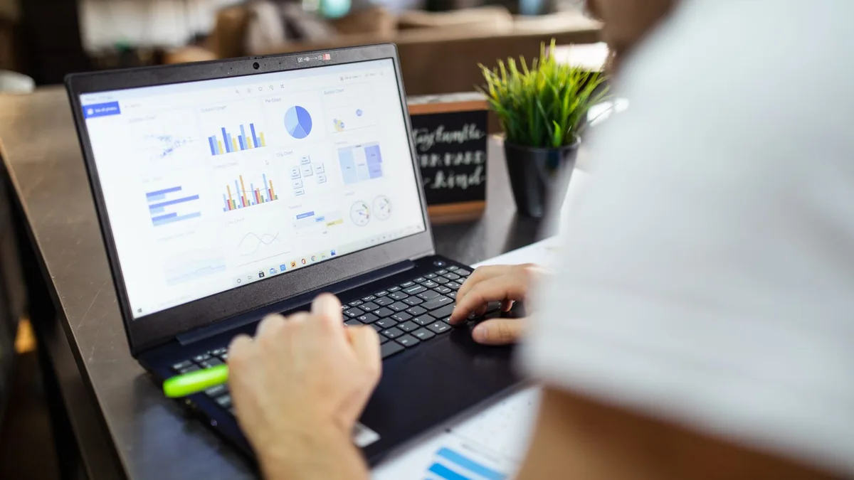 Printed charts and a laptop during a data analysis session, illustrating the ranking of the best data analytics agencies in France