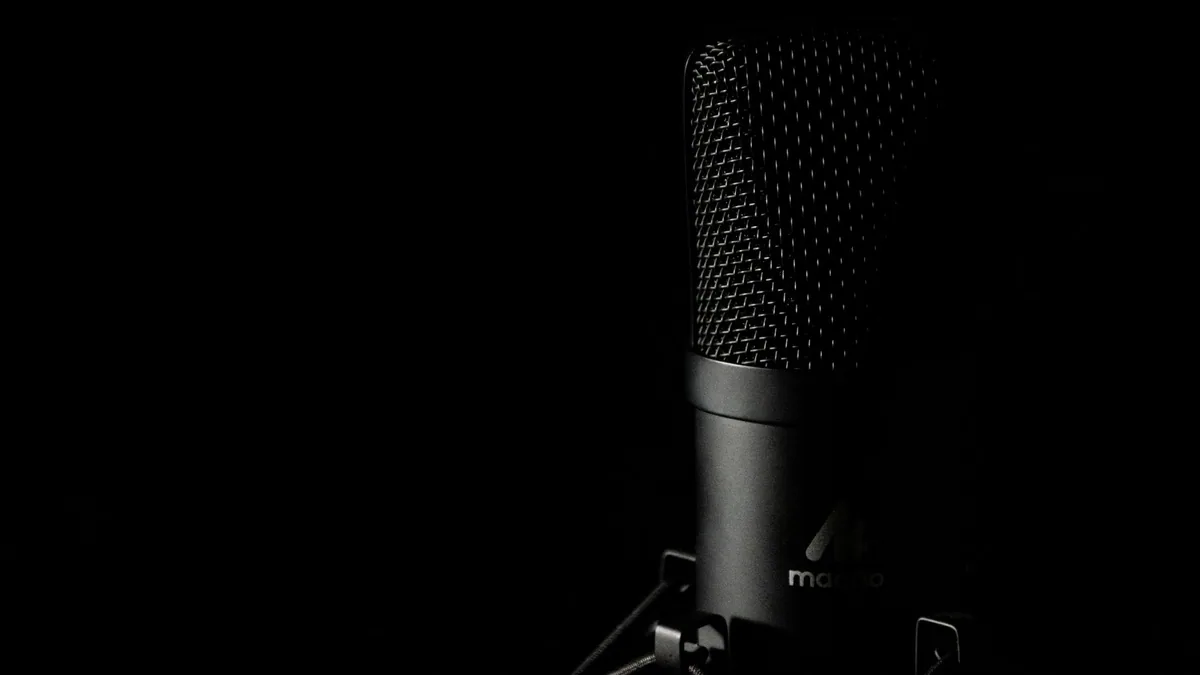 Microfono da studio fotografato su sfondo scuro, che illustra la classifica delle migliori agenzie podcast in Francia