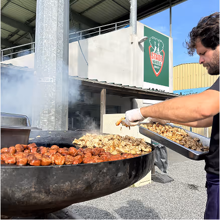 Cuisson de viandes sur un brasero lors d’un événement au Stade Nantais.