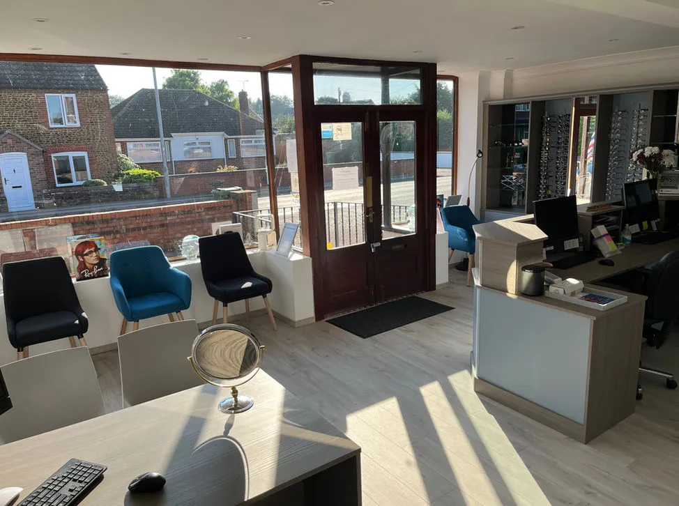 Bright optician's office with large windows, chairs, and reception desk