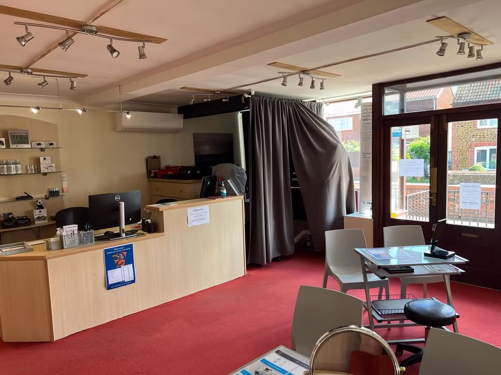 Modern office interior with red carpet, reception desk, and track lighting
