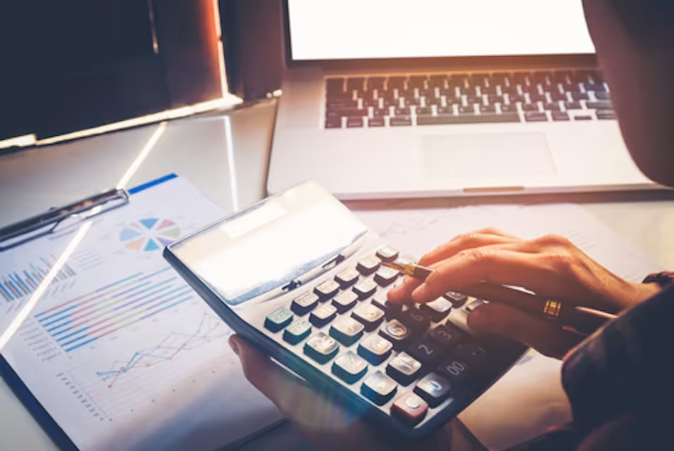 Close up of hands using a calculator at work