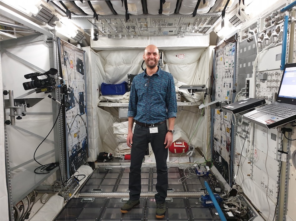 Rob Hubbard stands in the ground-based science module of the ISS