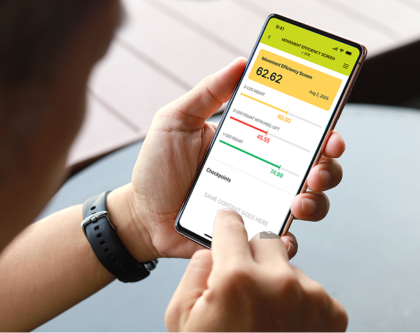 Person holding a smartphone displaying a Movement Efficiency Screen app showing scores for squats and lifts with color-coded results.