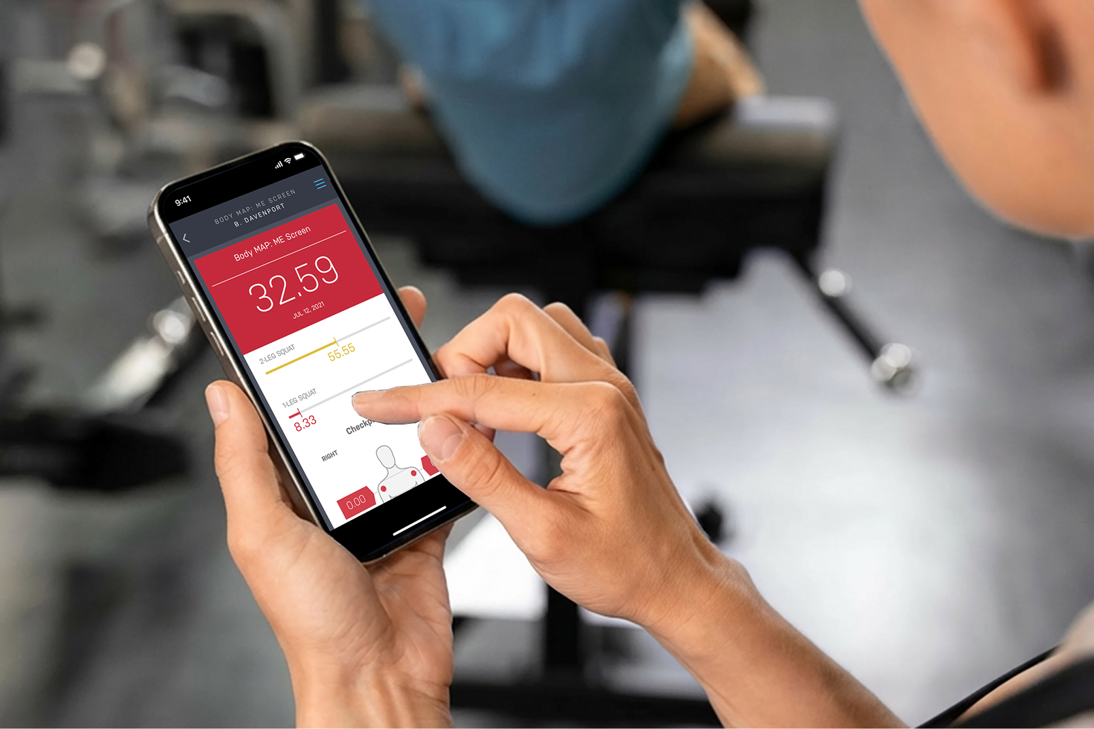 Person using a smartphone app displaying body map and squat exercise scores in a gym setting.