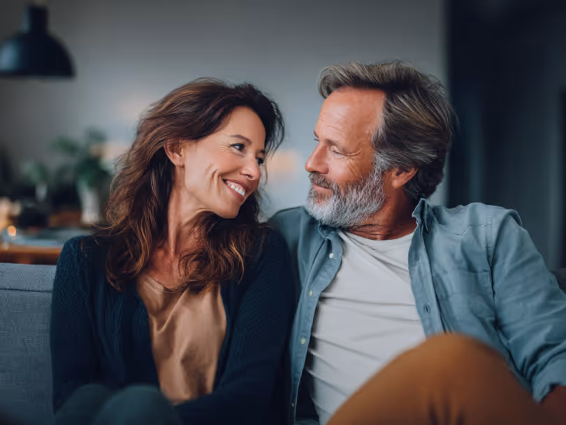A couple sitting on a couch with each other