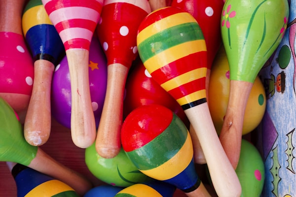 Colorful wooden maracas arranged together, showcasing vibrant patterns and designs in a festive display of musical instruments - A vibrant array of wooden maracas is grouped closely together, featuring diverse colors and patterns that invite playful participation in music-making, perfect for celebrations.