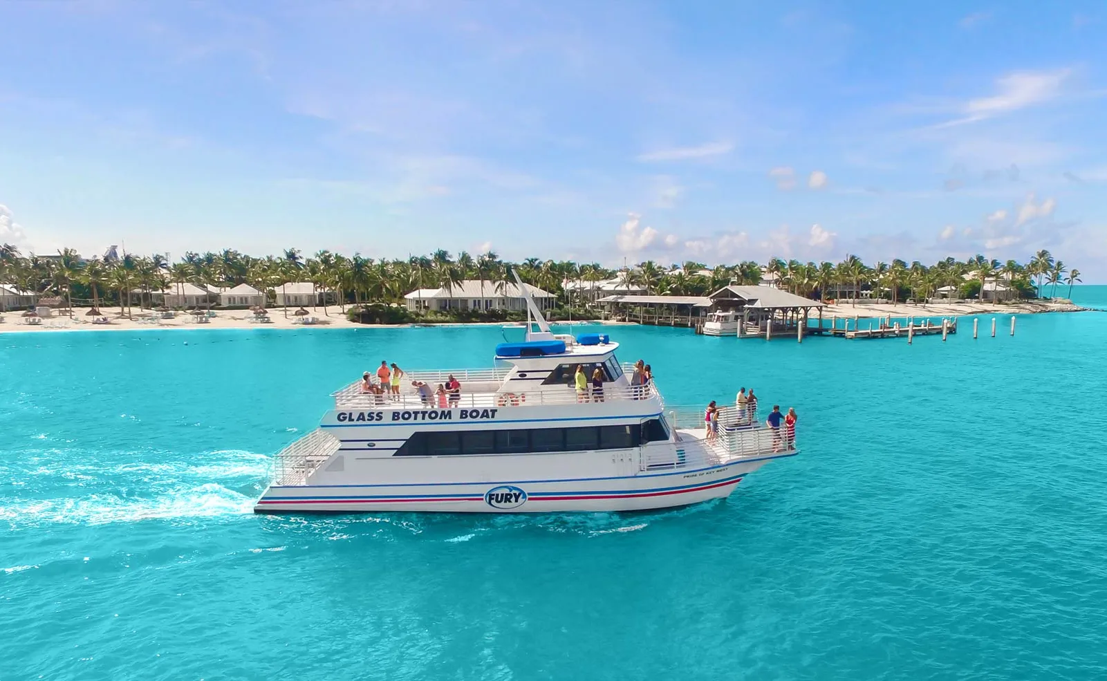Glass-bottom tour boat leaving the harbor on a sunny day.