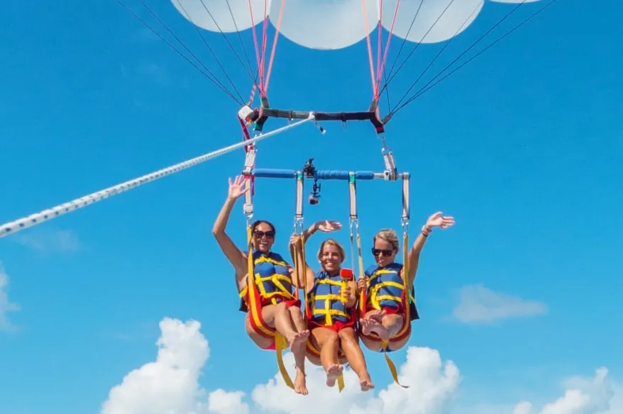 Close-up of girls para sailing high in the air.