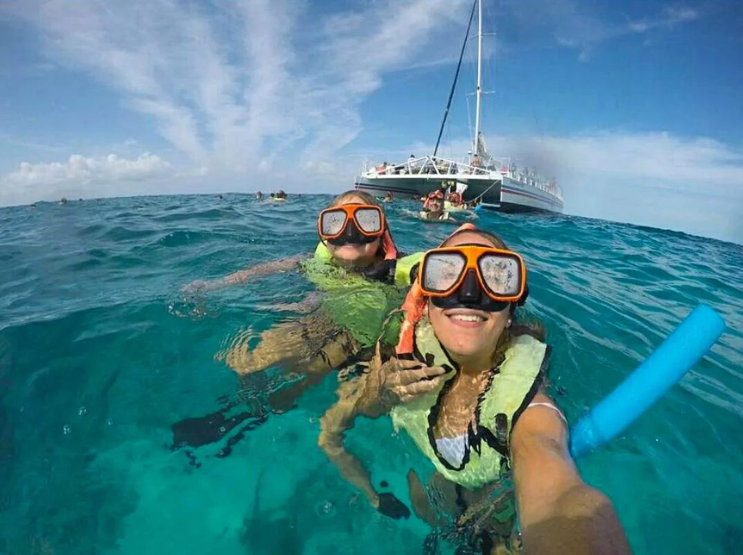 Two girls taking a selfie, while floating above the surface of the water.