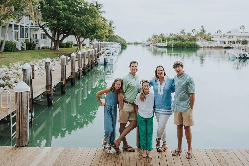 Attractive white family taking a group photo at the dock on an overcast day.