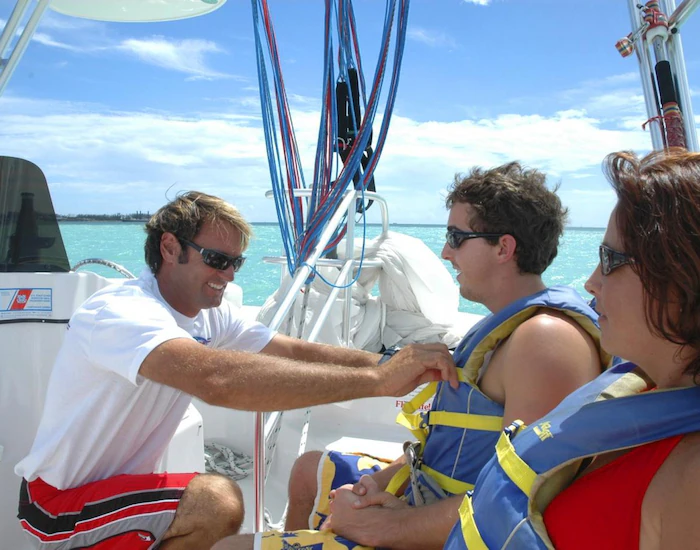 Boat captain giving instruction before couple goes parasailing.