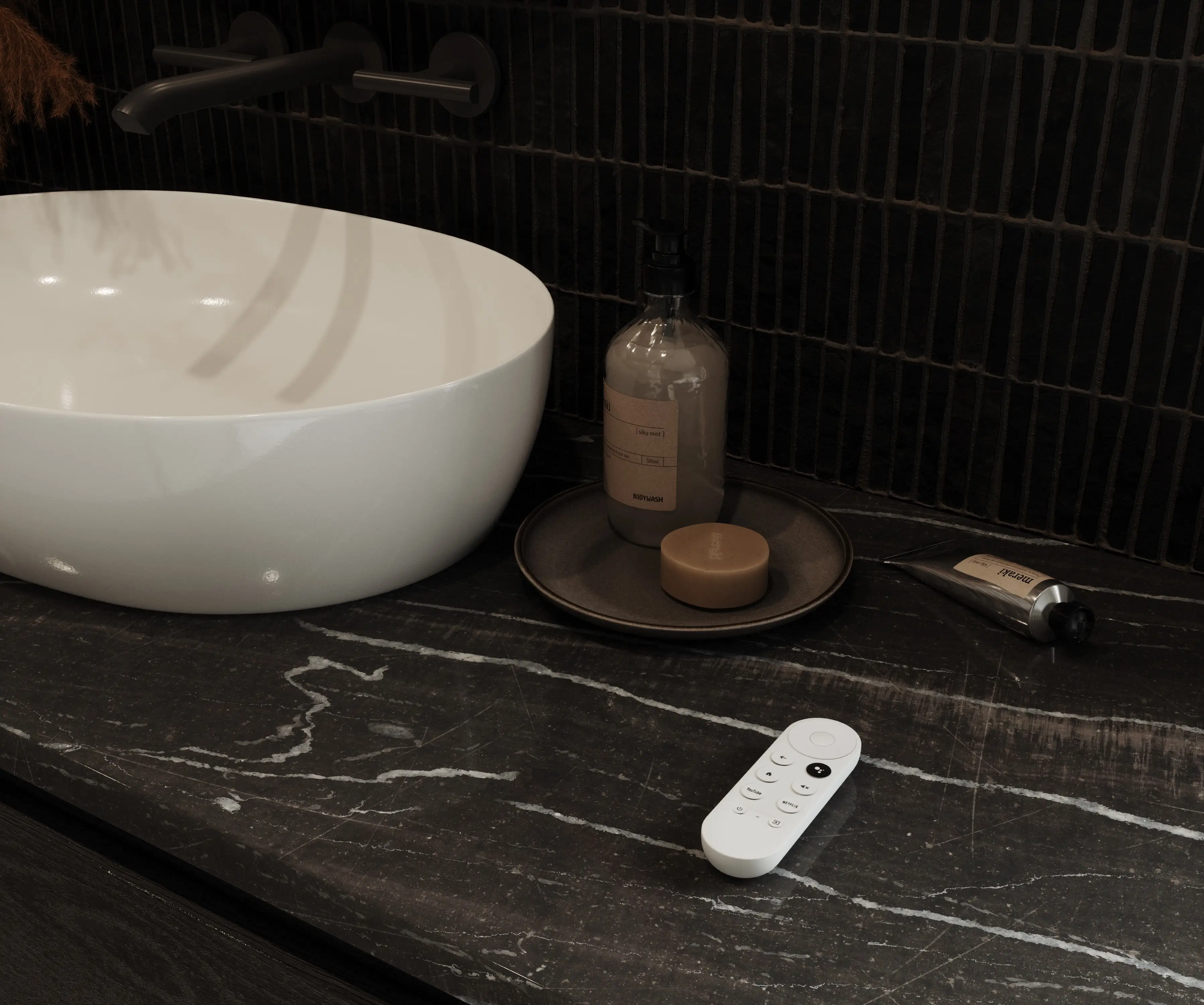 Biały pilot do zdalnego sterowania funkcjami inteligentnego lustra leżący na czarnym marmurowym blacie.