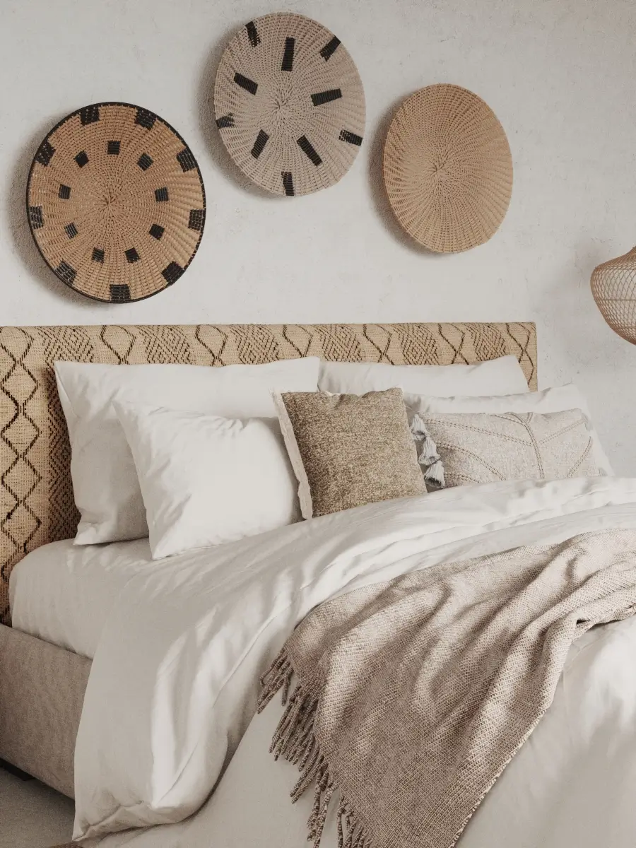 Sypialnia z plecionym zagłówkiem łóżka i dekoracyjnymi talerzami z wikliny na ścianie.