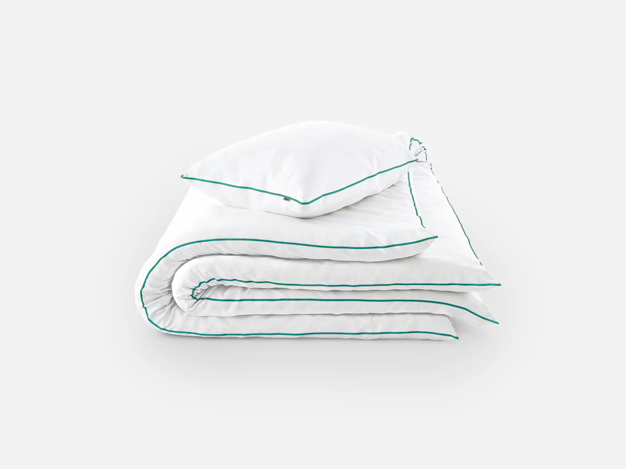 Złożona biała pościel z kontrastową zieloną lamówką i poduszką na wierzchu