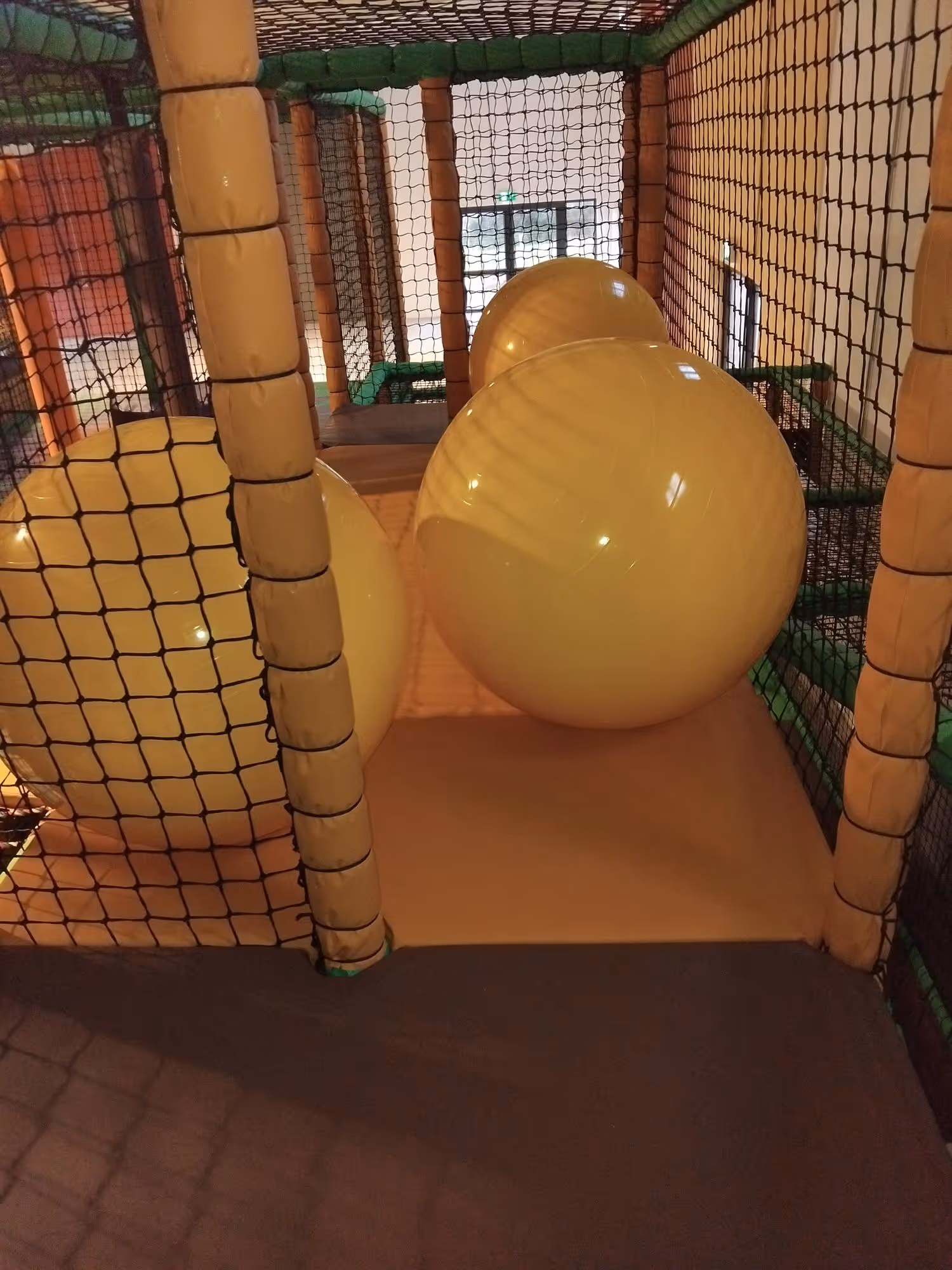 Indoor play area with large yellow inflatable balls.