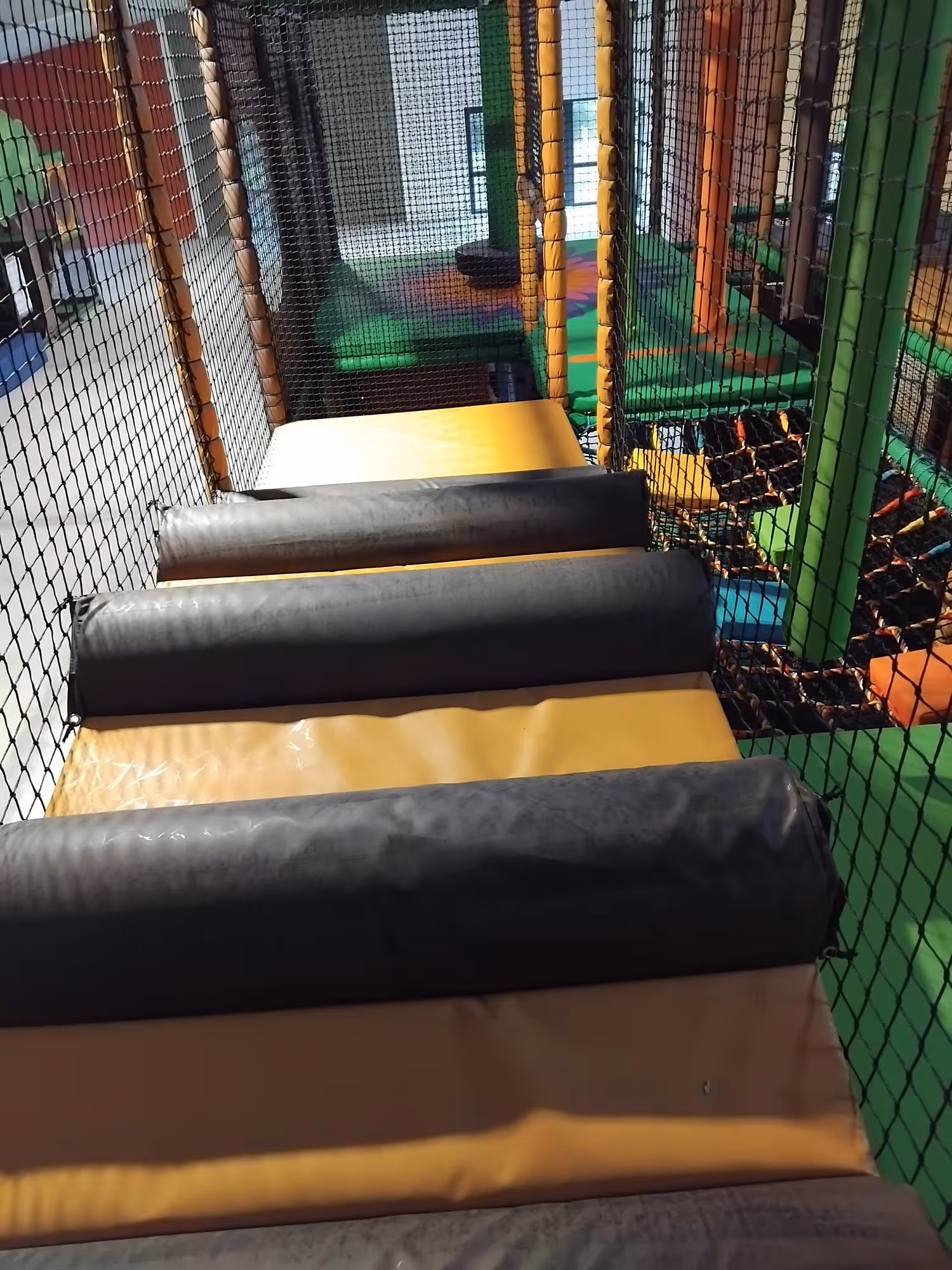 Close-up view inside an indoor soft play area with padded obstacles.