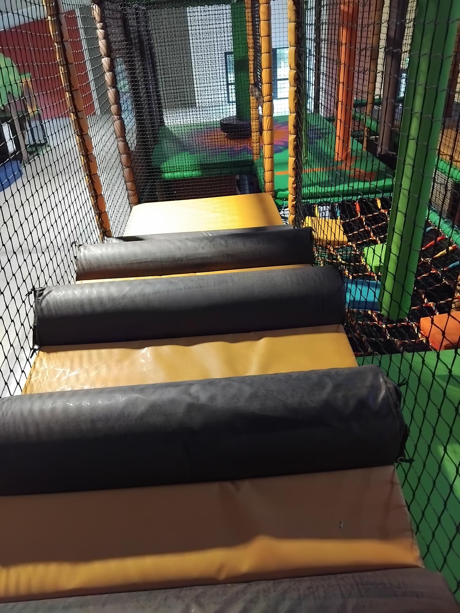 Close-up view inside an indoor soft play area with padded obstacles.