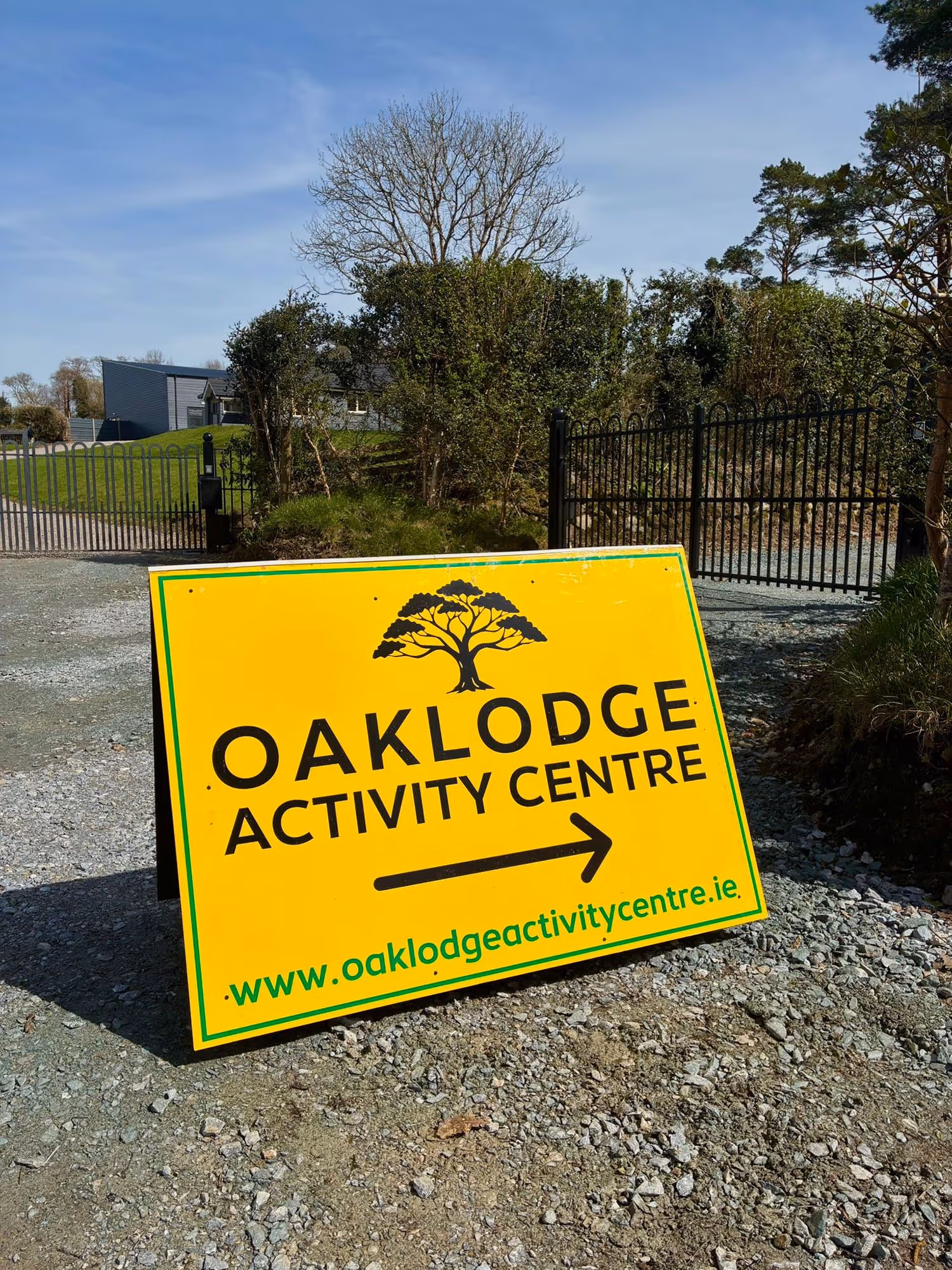 Yellow sign with a tree graphic pointing right to Oaklodge Activity Centre.
