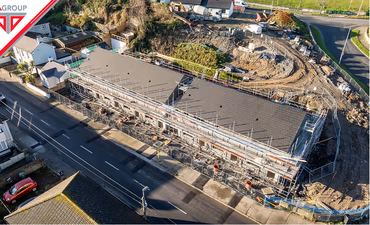Aerial view of a large building under construction with scaffolding and construction vehicles nearby.