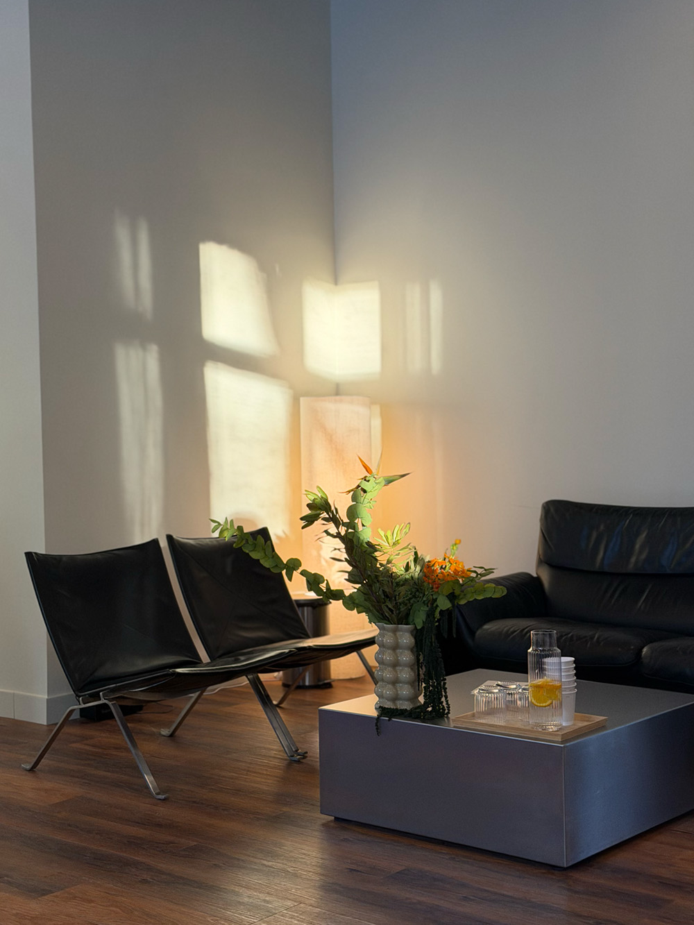 Trener wspierający kobietę w fioletowym stroju sportowym podczas ćwiczeń z hantlami.