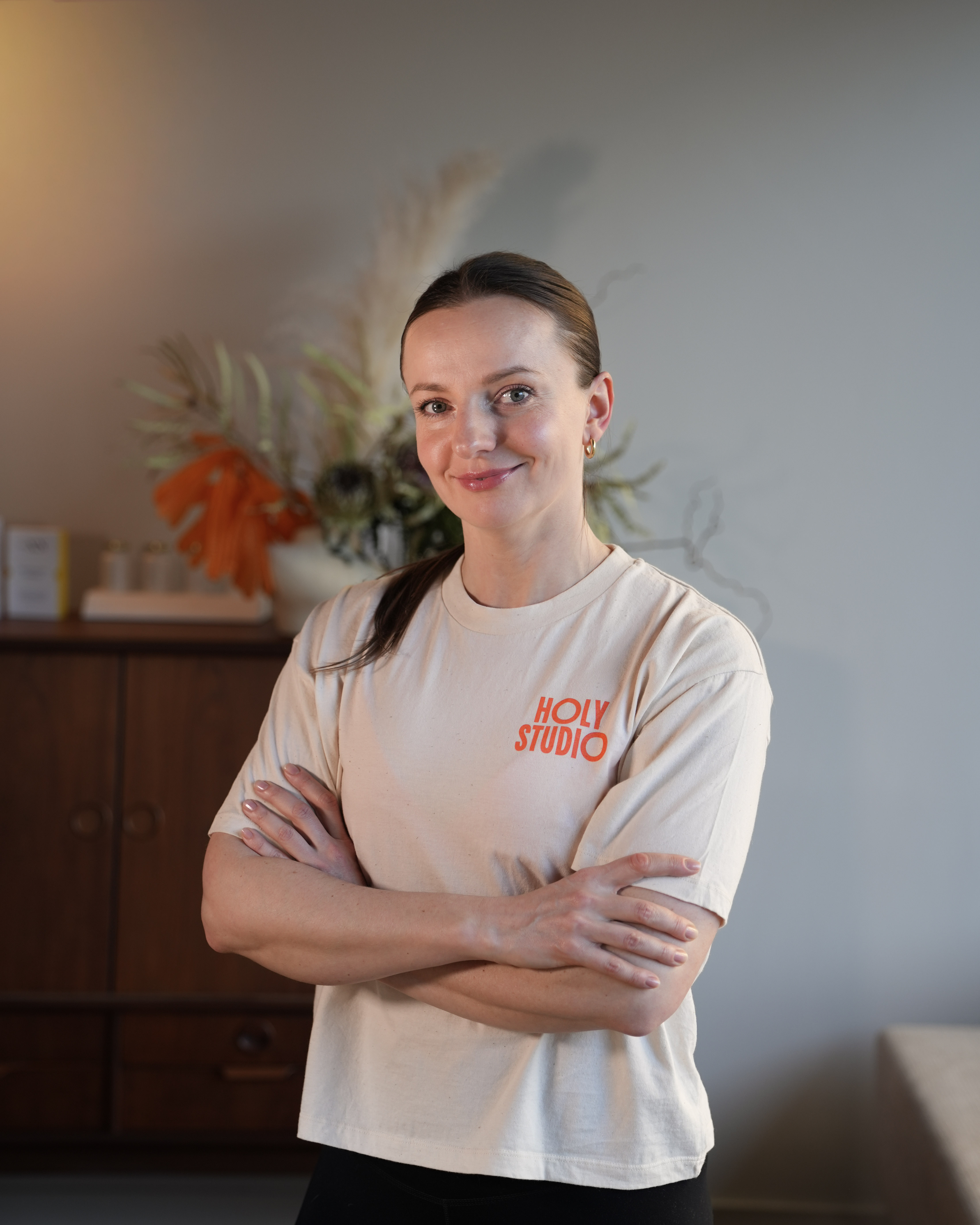 Trener instruuje kobietę trzymającą kettlebell podczas ćwiczenia przysiadu.