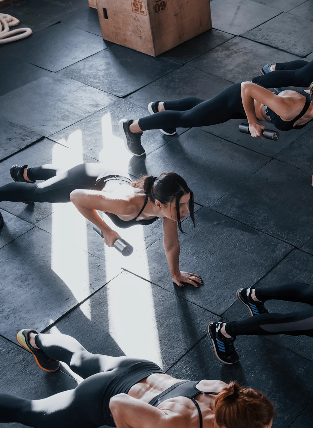 Trener instruuje kobietę trzymającą kettlebell podczas ćwiczenia przysiadu.