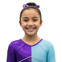 Smiling young girl wearing a purple and light blue gymnastics leotard with a matching purple hair bow.