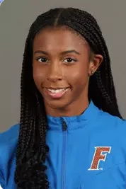 Young woman with long braided hair wearing a blue sports jacket with an 'F' logo.