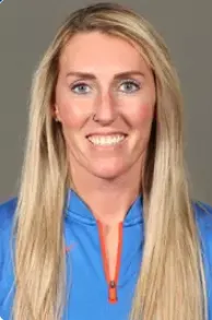 Portrait of a smiling woman with long blonde hair wearing a blue jacket with an orange zipper.