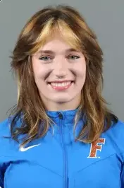Young woman with shoulder-length light brown hair wearing a blue sports jacket with an orange and white F logo.