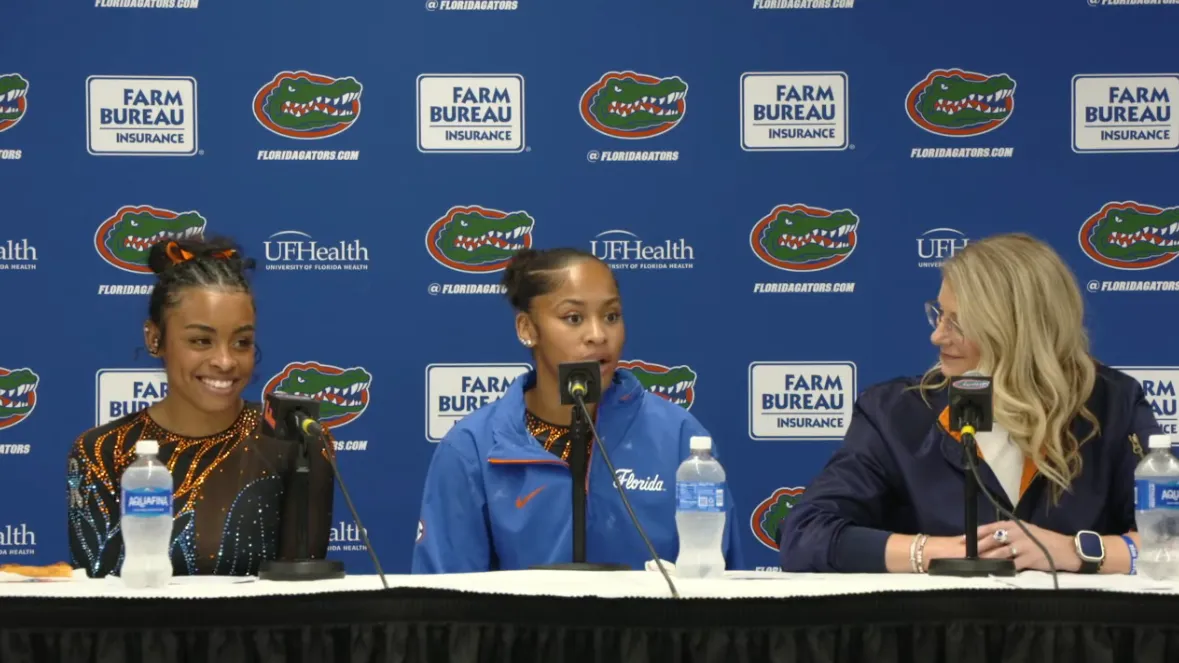 Gymnast performing an advanced handstand on parallel bars in an indoor gymnasium.