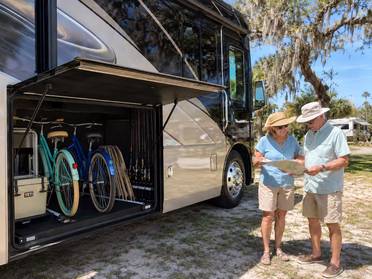 Couple loading beach gear into a luxury motorhome storage bay
