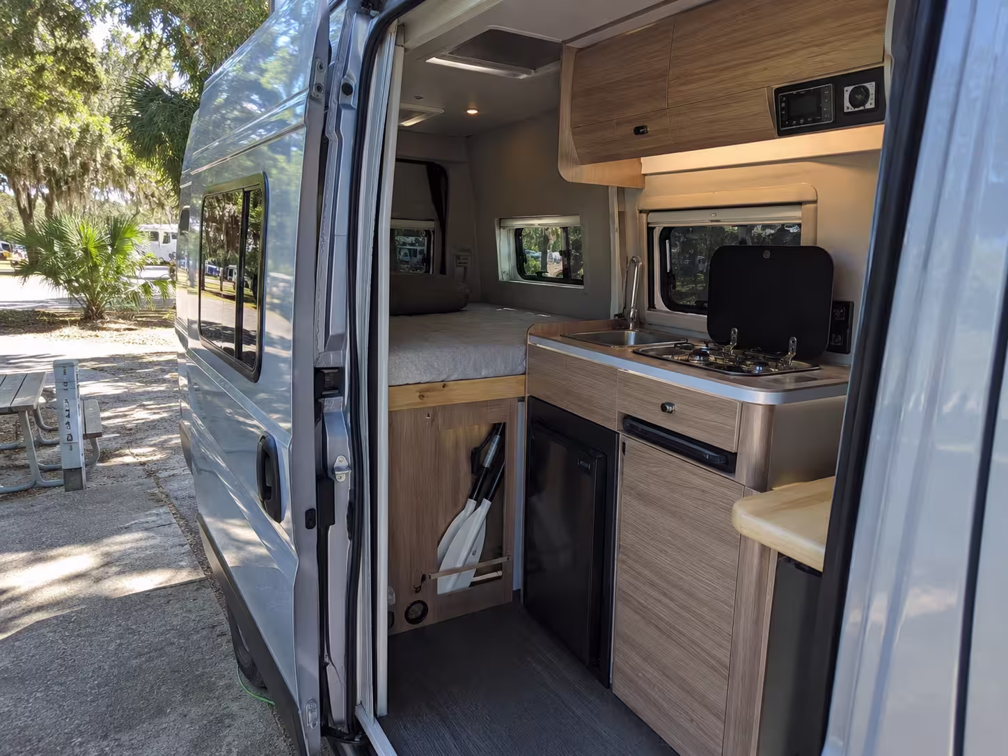 Camper van interior with galley and rear bed