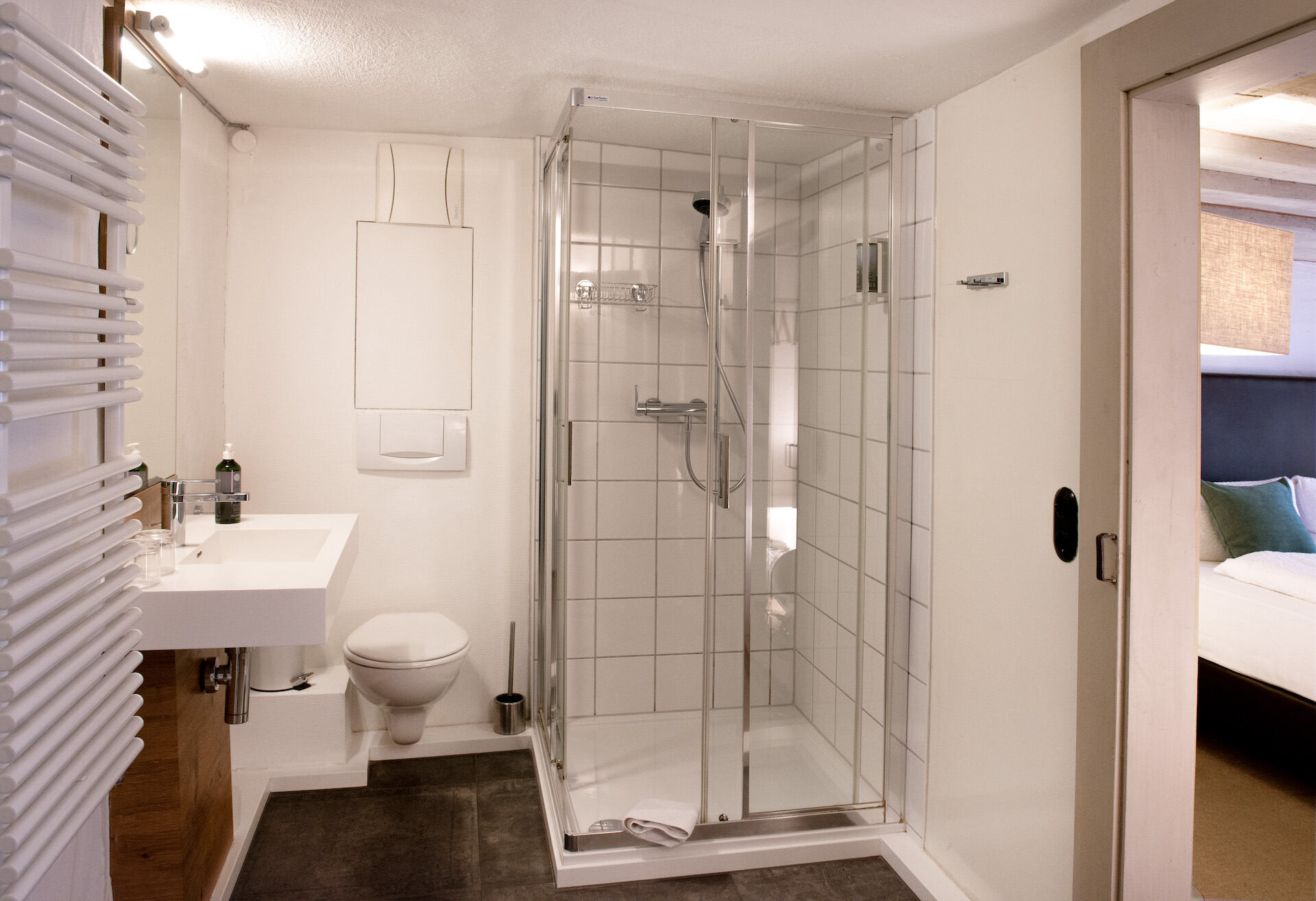 Badezimmer mit Toilette, Waschbecken, Spiegel und Dusche