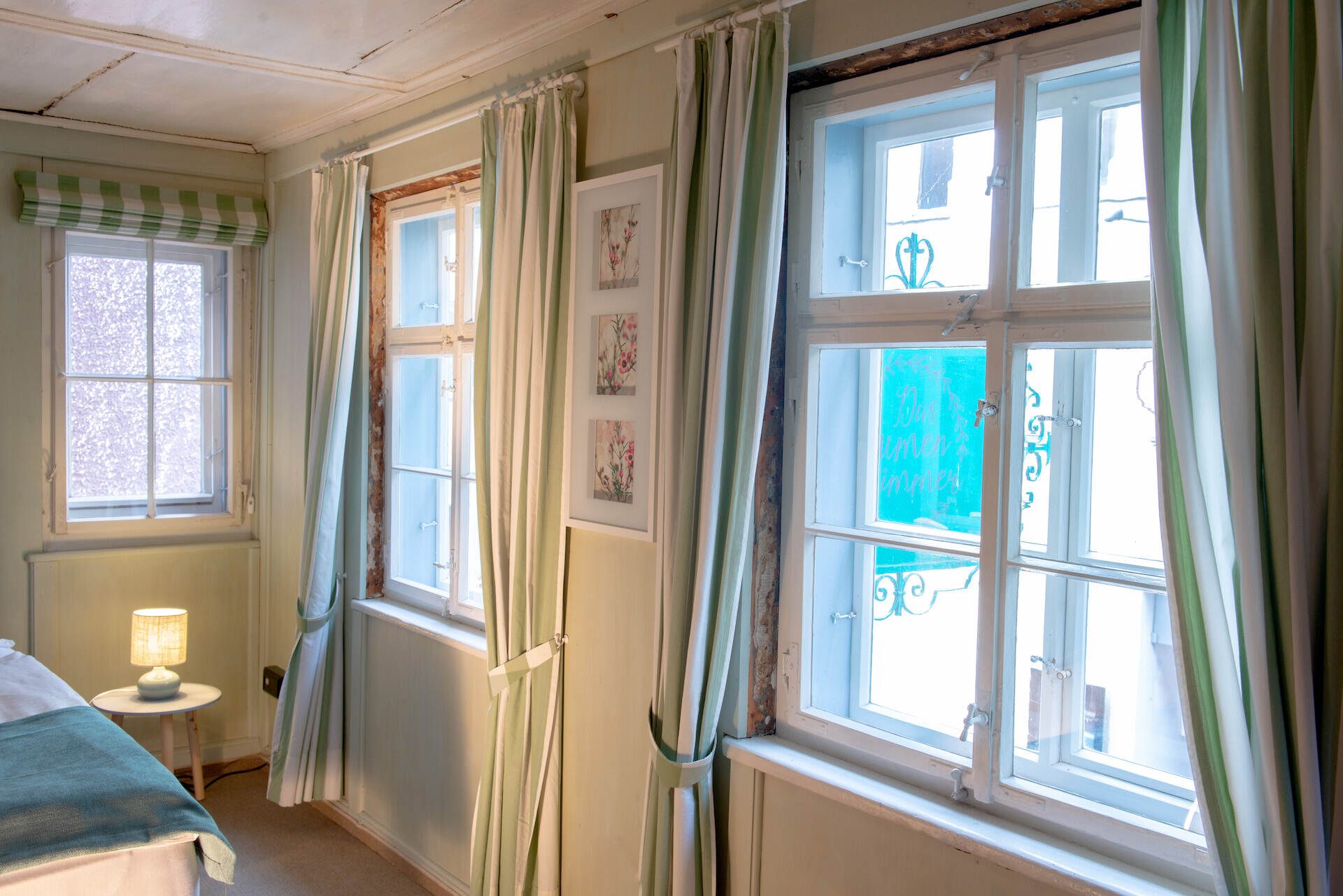 Nachttisch mit Nachttischlampe, Wandbild, Fenster mit Vorhaengen