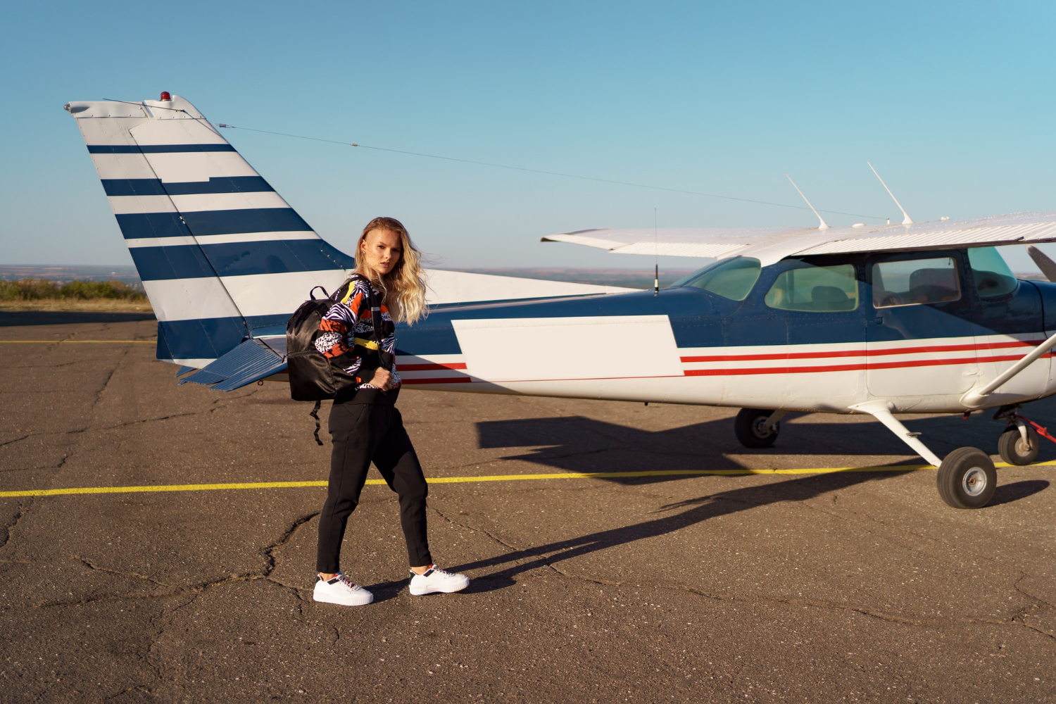 A woman standing in front of a small airplane.